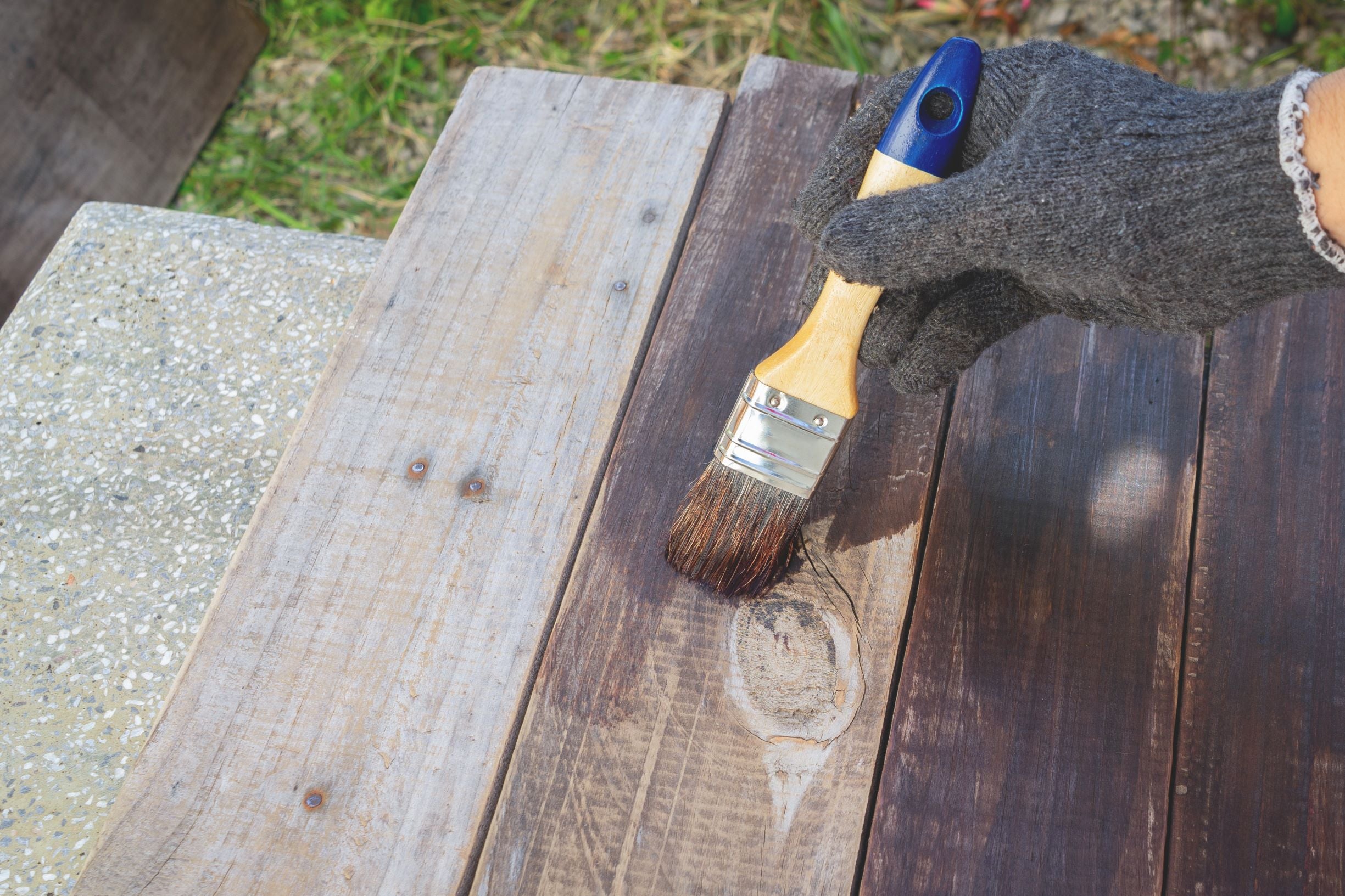 Painting a dark stain over wood.