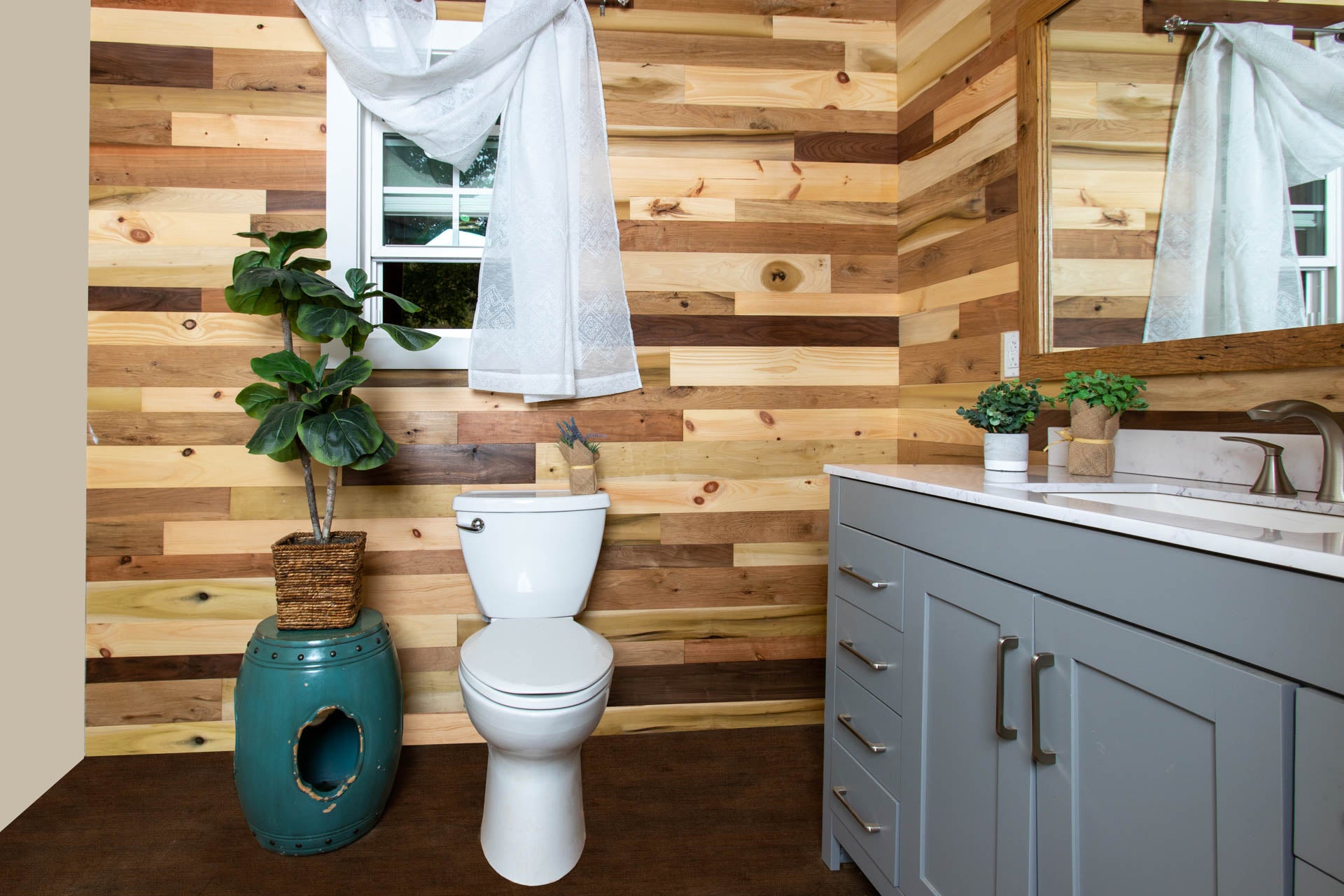 Vintage multicolored reclaimed wooden plank wall in a trendy bathroom.