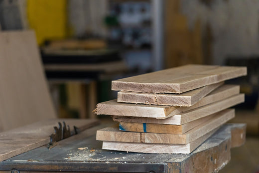 Stacked planks of reclaimed wood in a workshop.